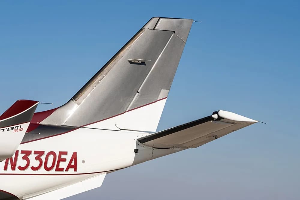 Close-up of the tail of a Daher TBM 900 aircraft, showing the registration N330EA and "TBM 900" logo.