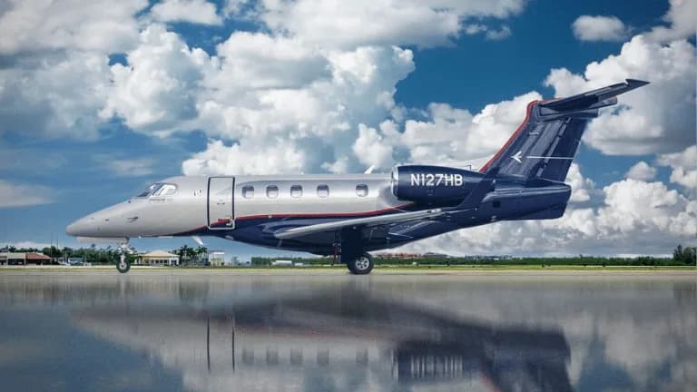 Side view of a Phenom 300 aircraft with registration N127HB on the tarmac.