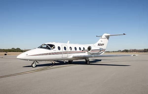 Side view of a white and black Eclipse 500 jet on the tarmac.