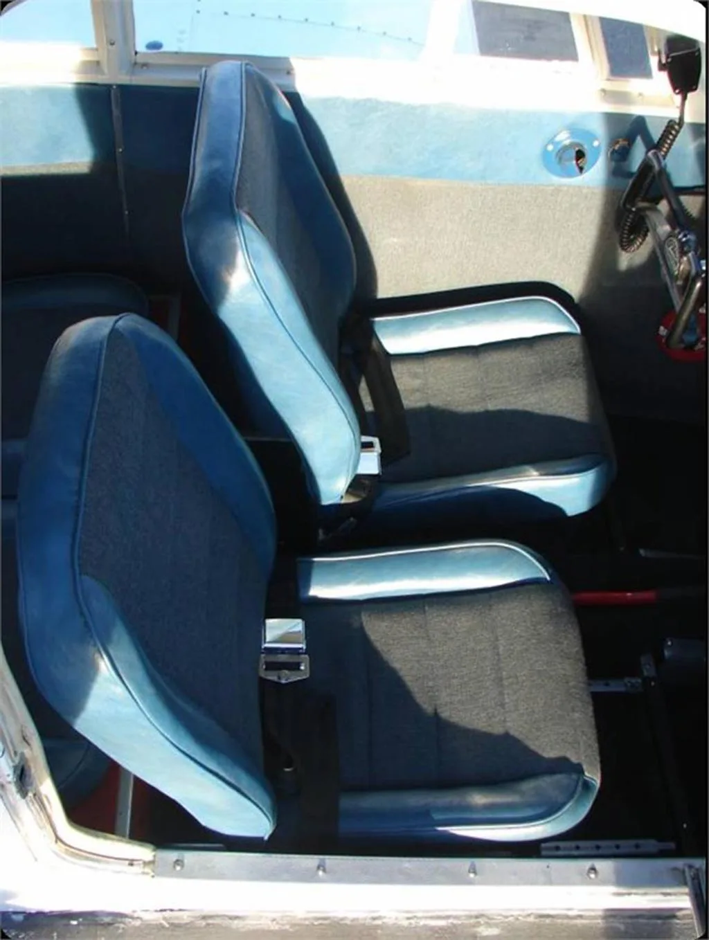The blue and gray interior cabin seats of a small aircraft.