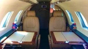 Interior view of the aircraft cabin with seats and tables.