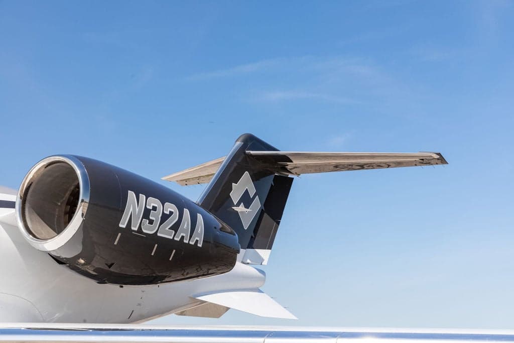 Close-up of the tail and engine of a Learjet 45XR with registration N32AA.