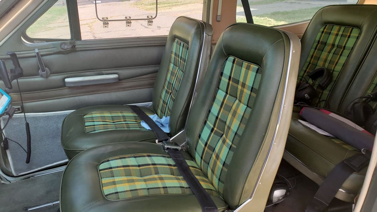 The interior of the aircraft features green plaid seats.