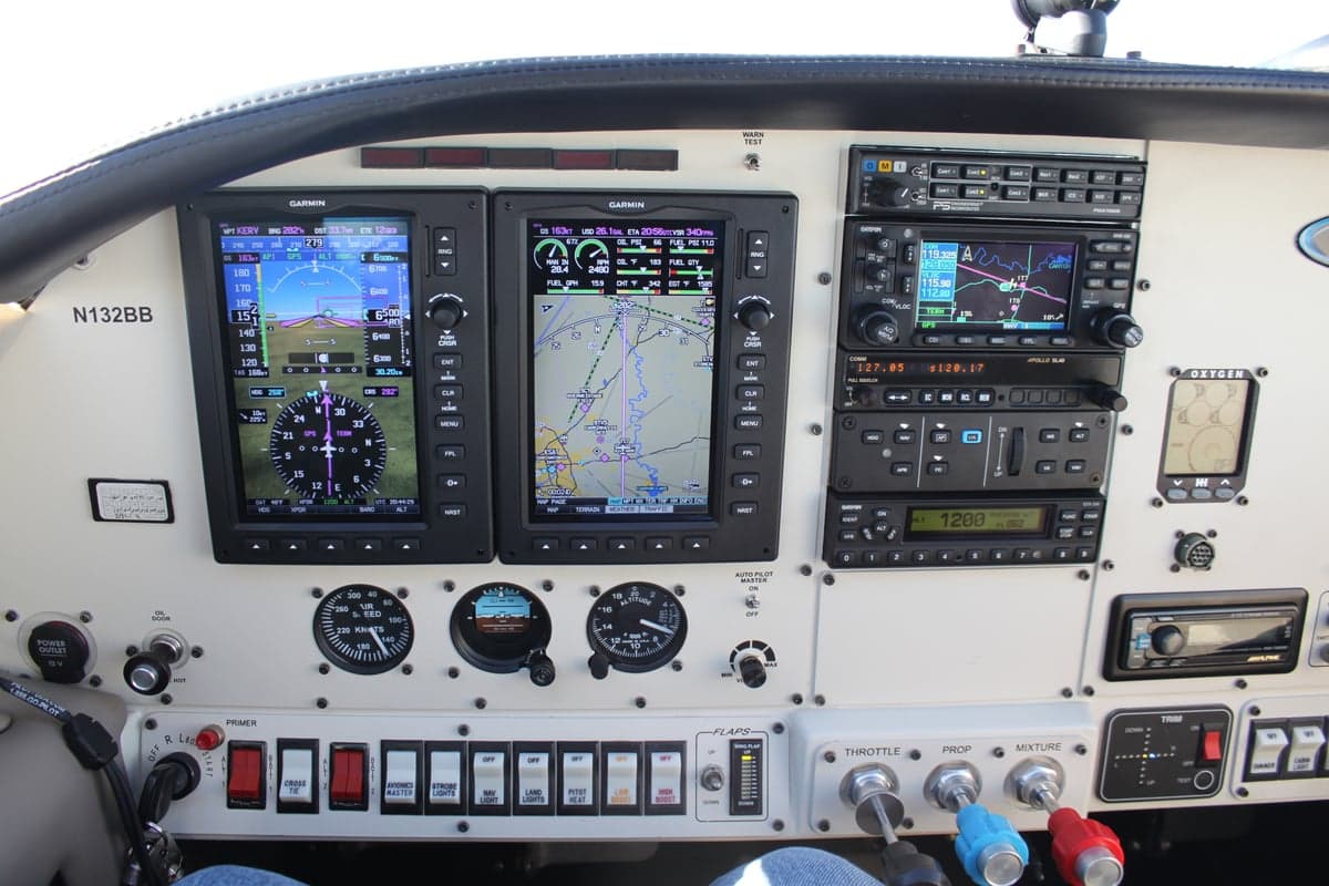 The aircraft's instrument panel features Garmin avionics and various controls.