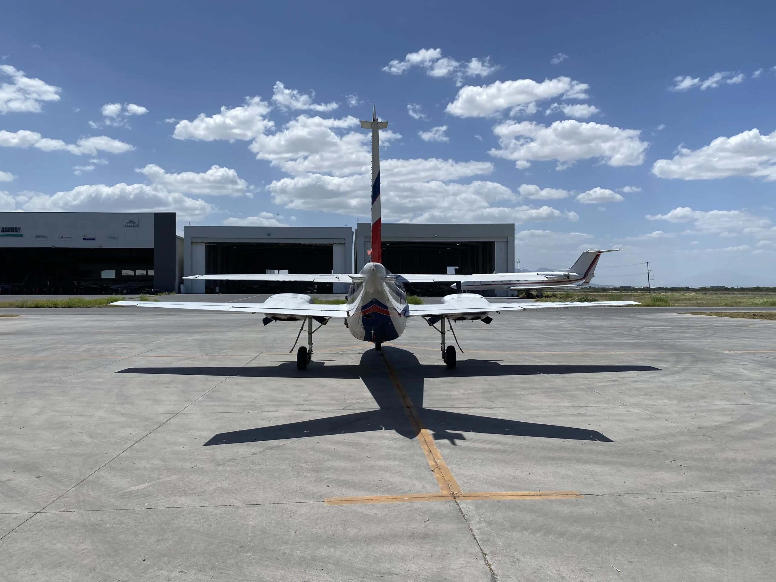 Rear view of the XB-DMF aircraft parked on the tarmac.
