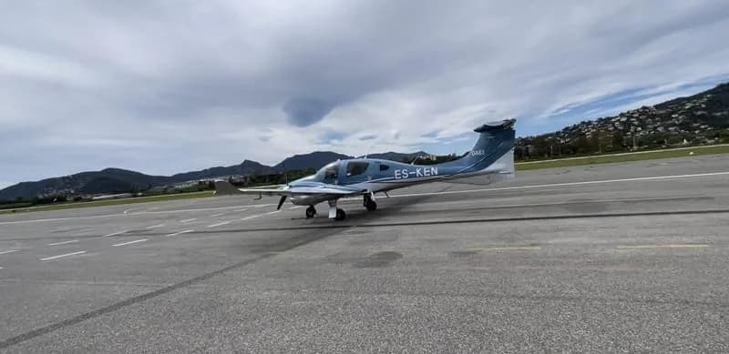 Diamond DA62 aircraft on the tarmac with mountains in the background.