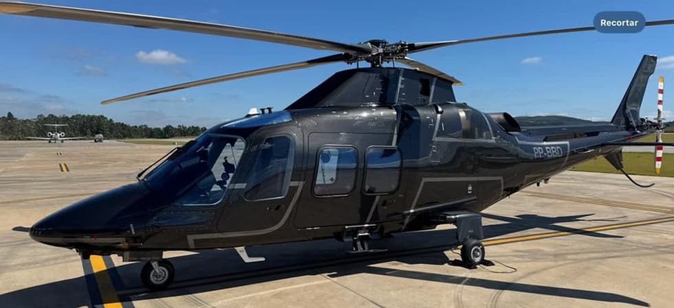 A black helicopter with registration PP-BBD sits on the tarmac.