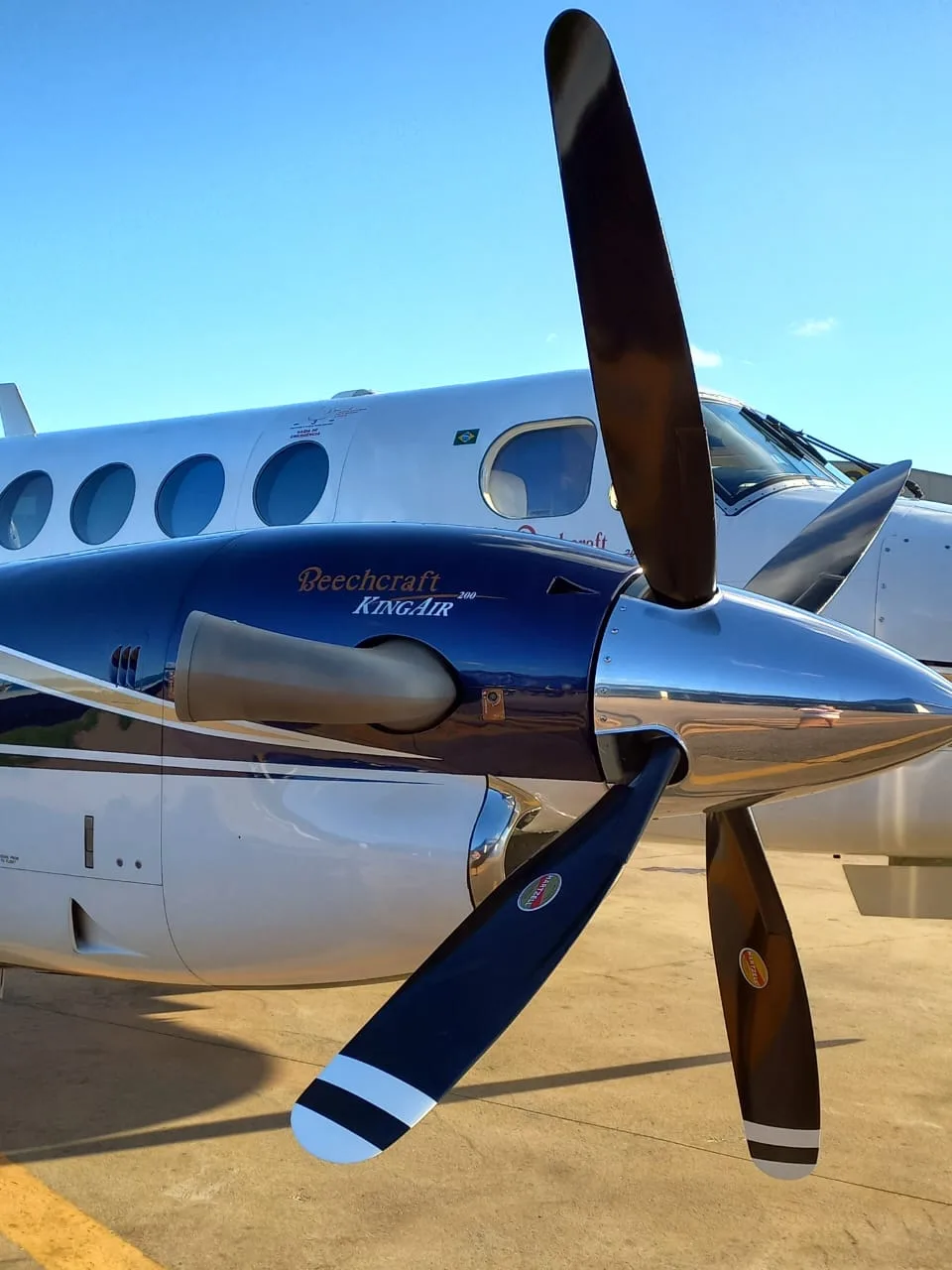 Close up of the propeller and engine cowling of a Beechcraft King Air 200 with the aircraft in the background.