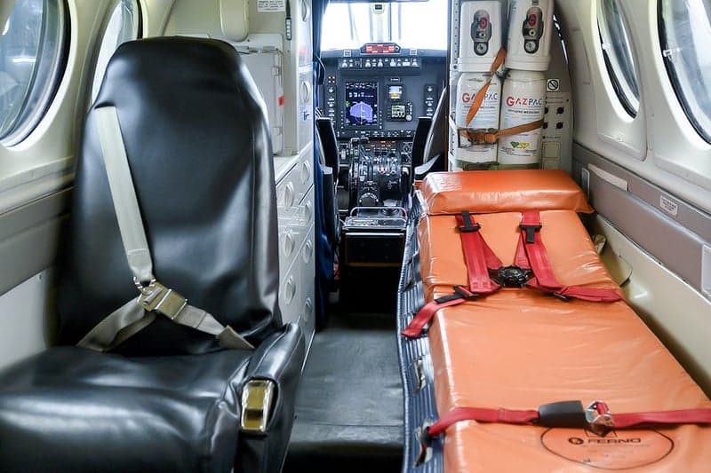 Aircraft interior with a seat and a stretcher.