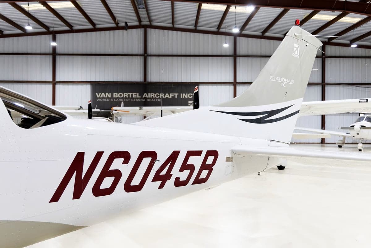 A close-up of the tail of a white Cessna Stationair TC (N6045B) with black and grey accents, showing the registration.