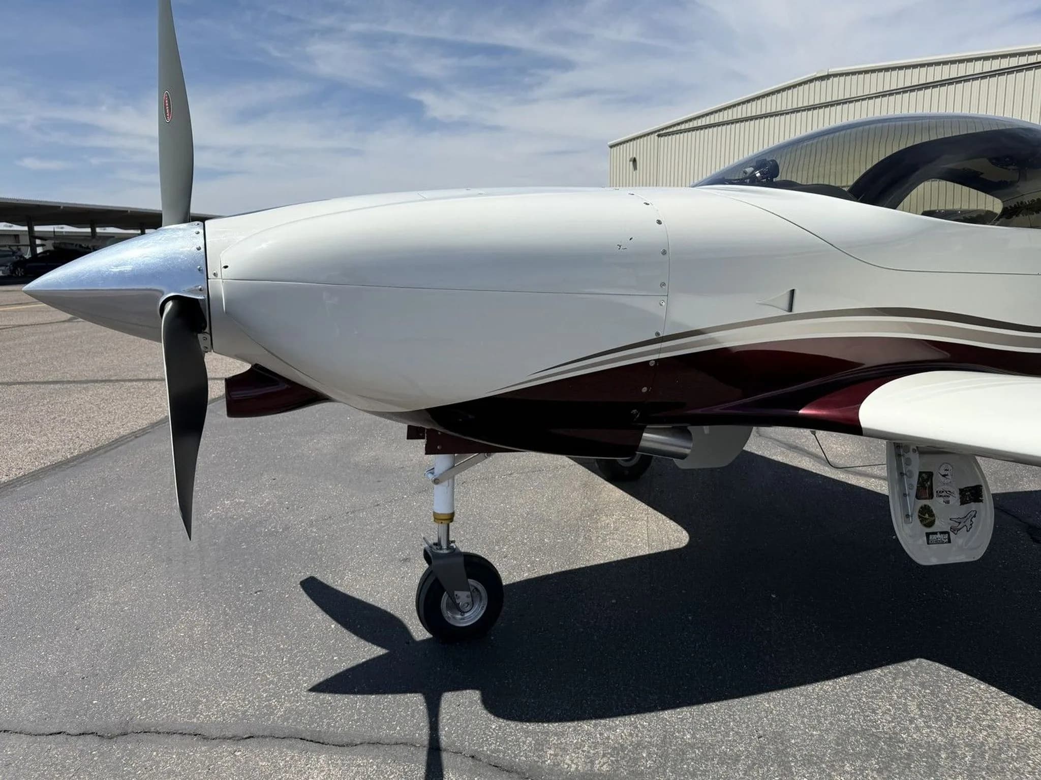 A close-up view of the propeller and nose of the white and maroon aircraft (N49LJ).