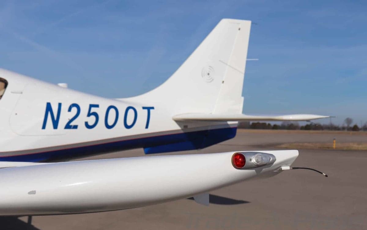 Close-up of the tail section of a white Columbia 400 aircraft showing registration N2500T on an airfield.