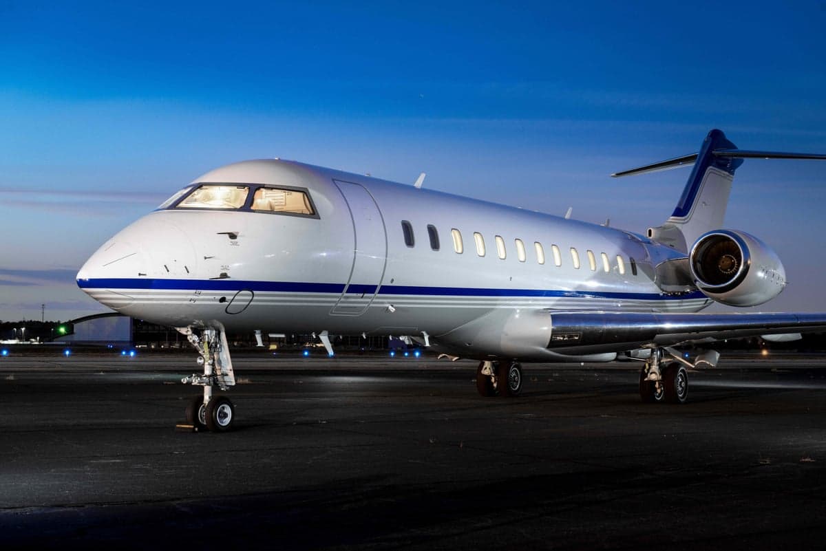 A Bombardier Challenger aircraft parked on the tarmac at dusk.