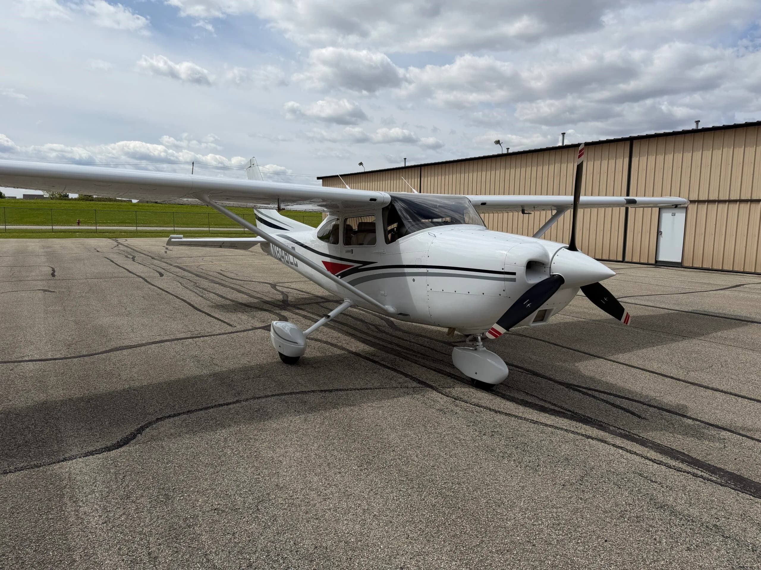 A white Cessna Skylane aircraft with registration N846LC is parked on an airport tarmac in front of a hangar.