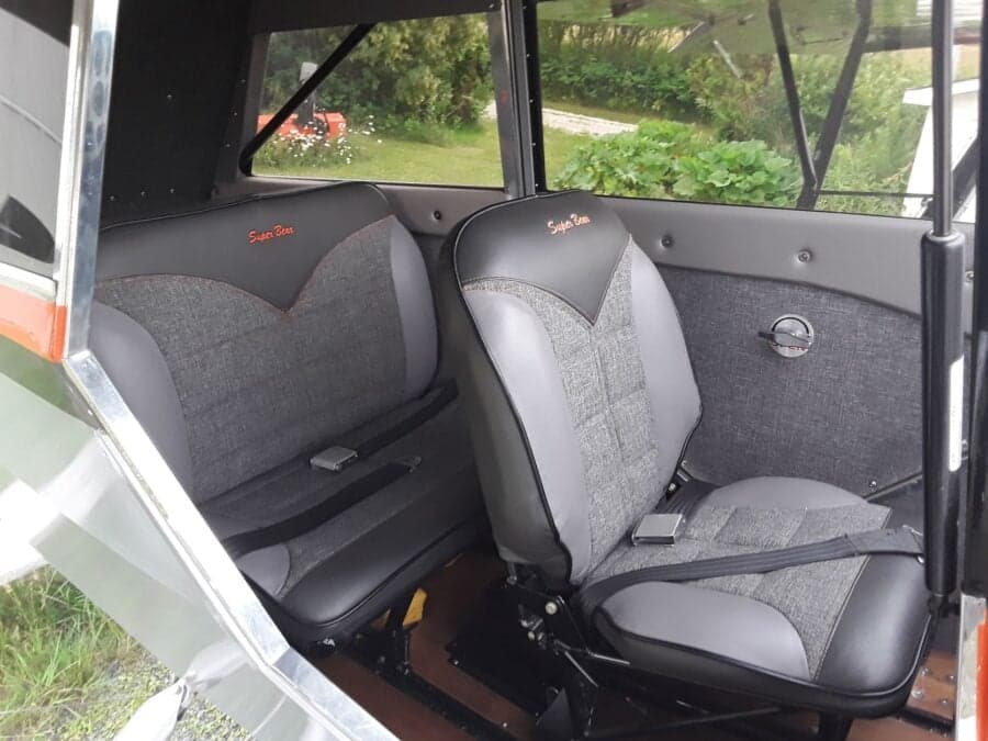 The interior of the Super Cub features two gray seats with black trim and the words 'Super Bear' embroidered on the headrests.
