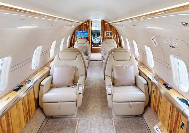 The interior of the Challenger aircraft features wood paneling and leather seats.
