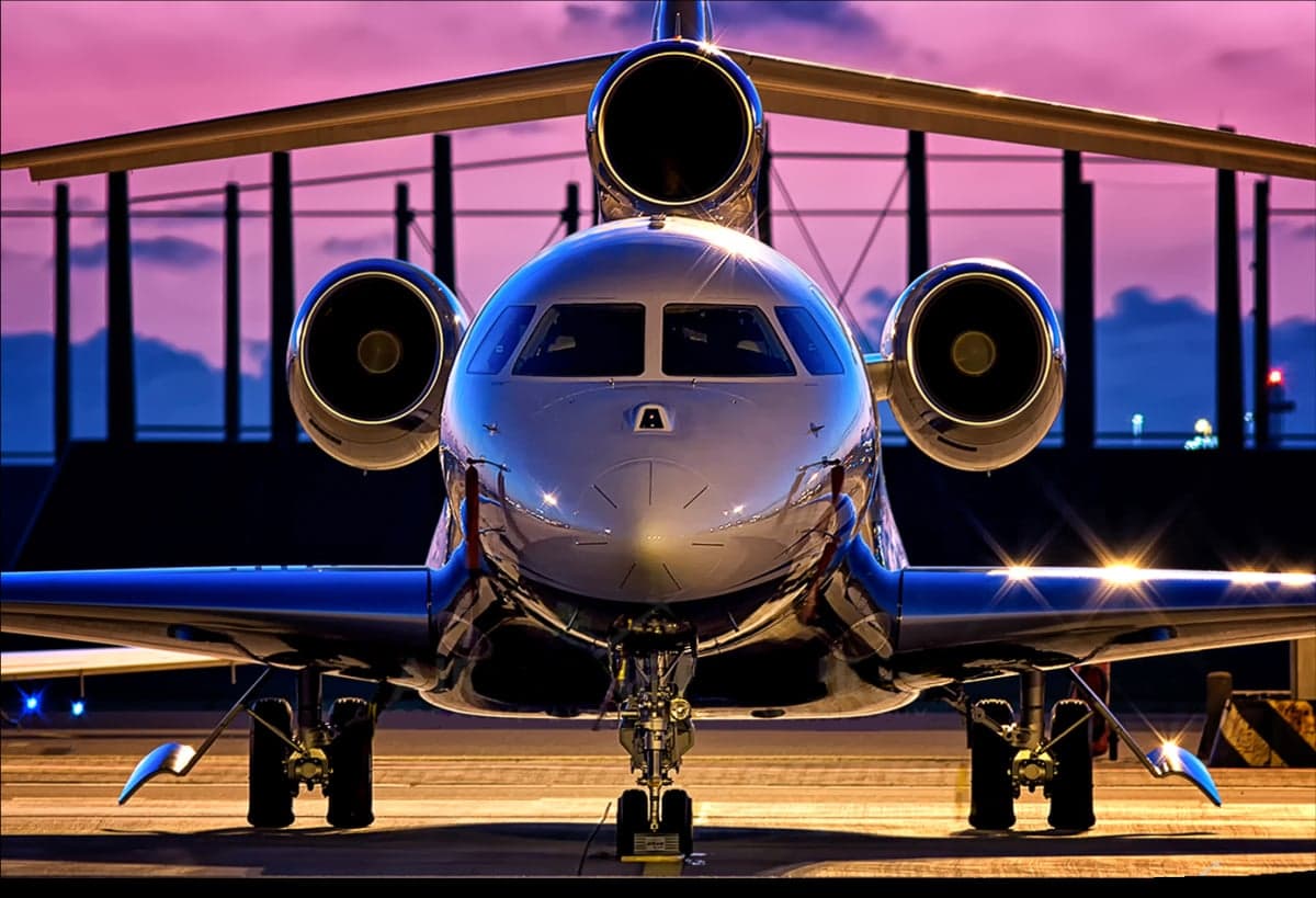 Front view of a private jet on the tarmac at dusk.