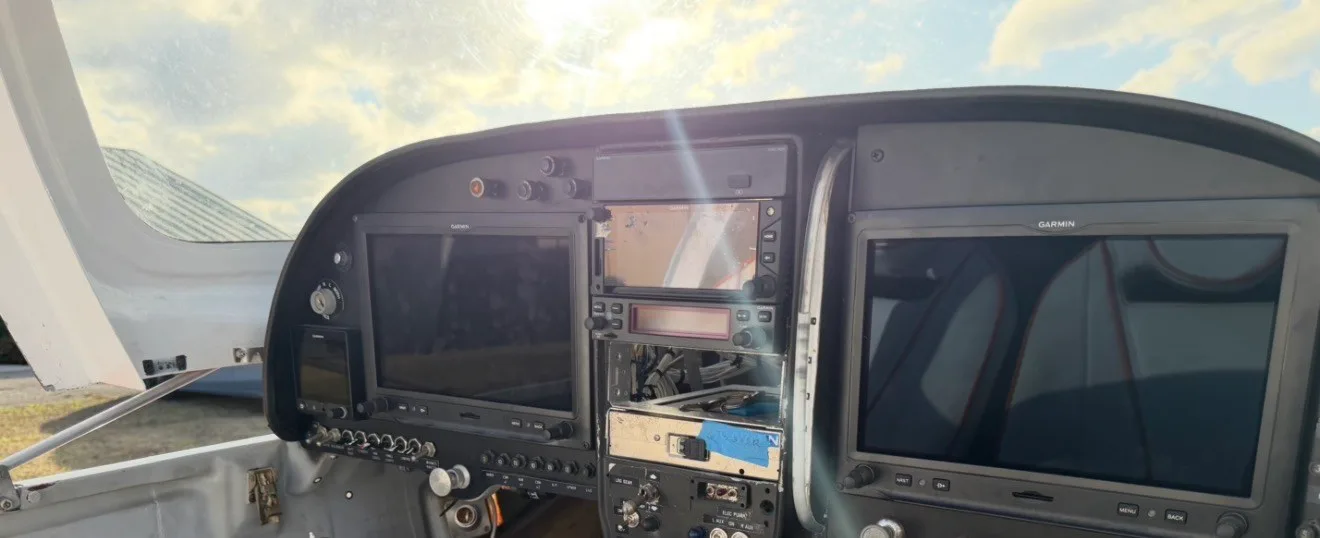 The cockpit instrument panel of an aircraft, featuring multiple Garmin displays and avionics.