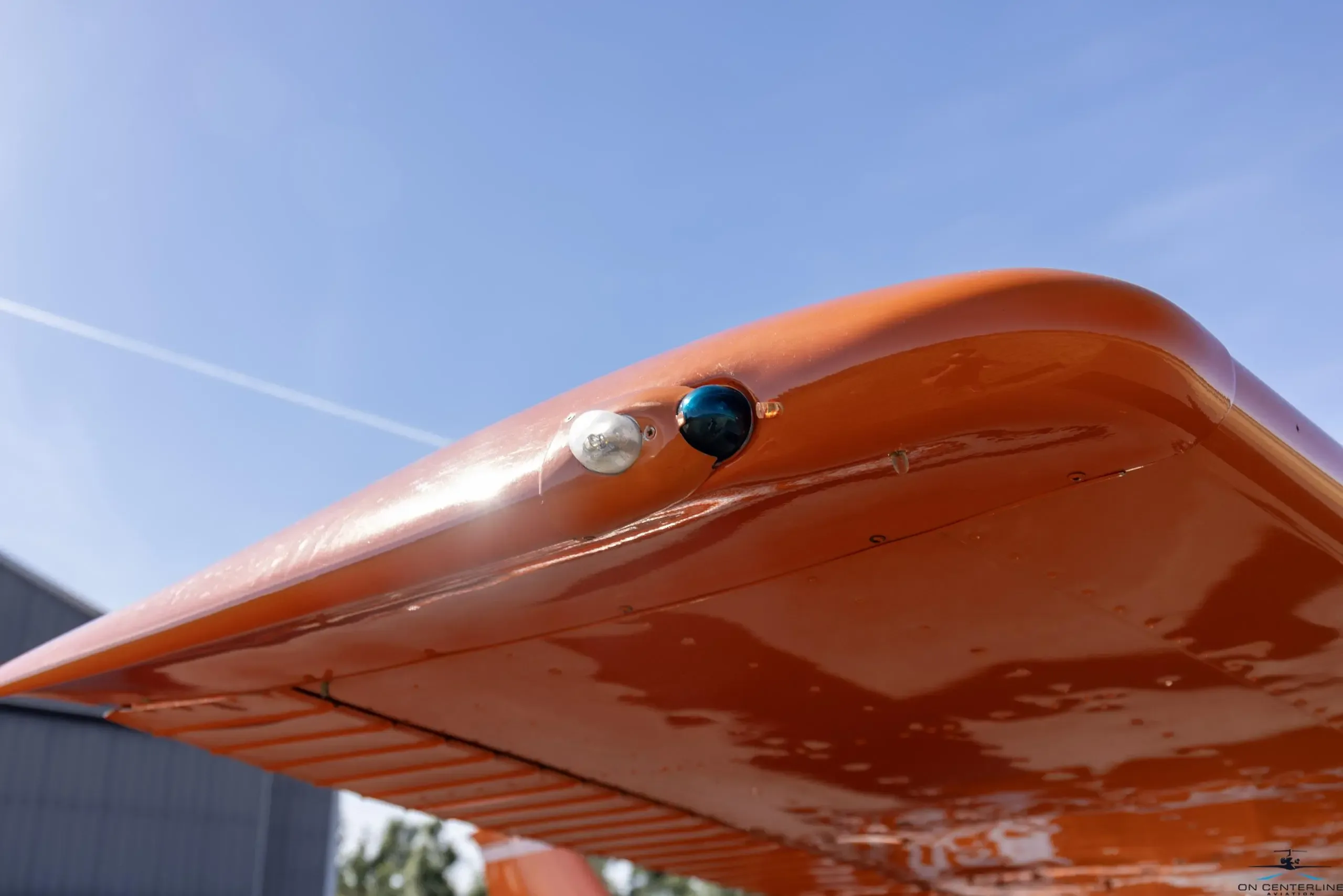 Close-up of the wingtip of the orange and white Cessna 182 Skylane RG.