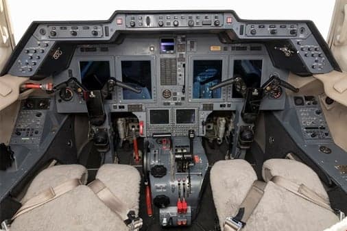 A detailed view of a modern aircraft cockpit featuring multiple digital displays and control panels.