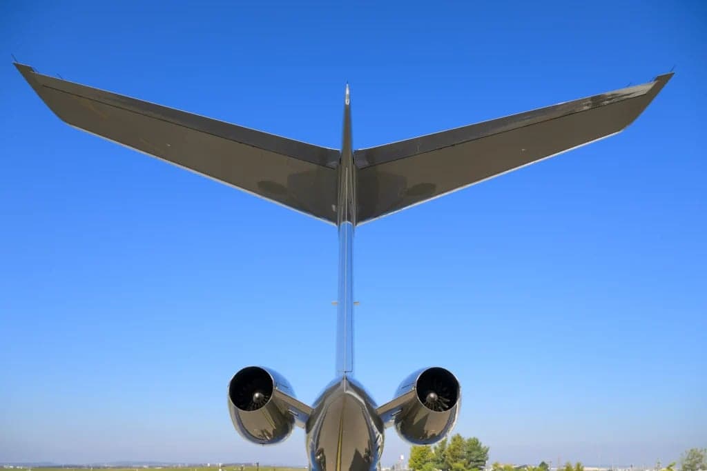 Rear view of a gray Gulfstream jet showing the tail and engines.