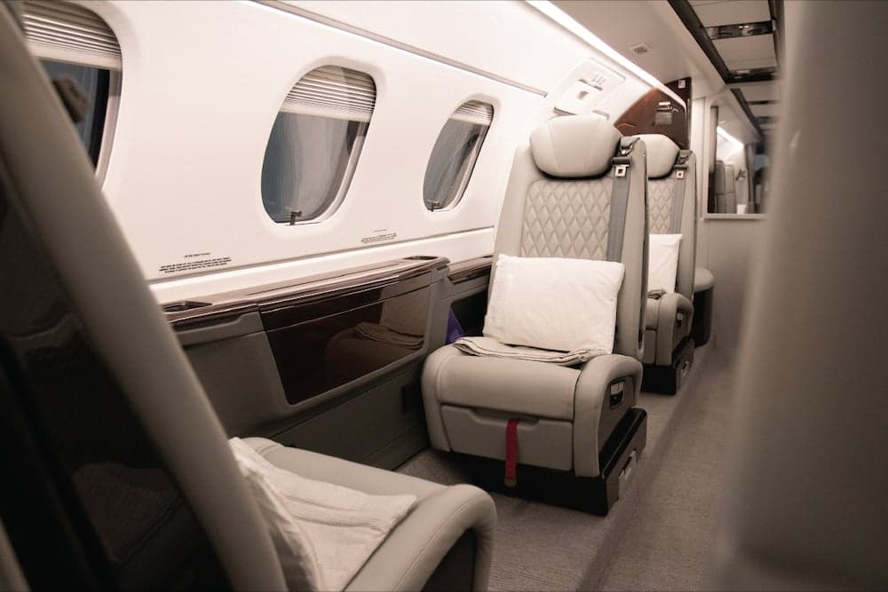 Aircraft interior with leather seats and window view.