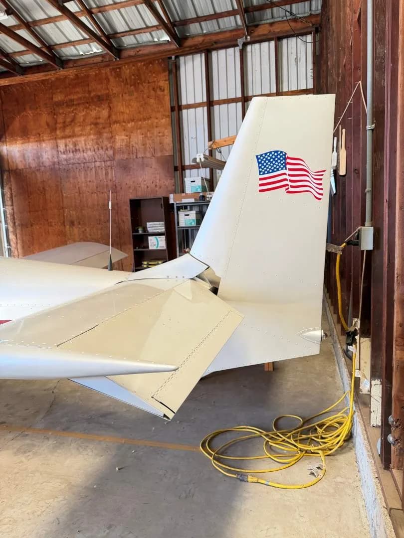 A close-up of the white tail of the Zodiac CH601 XL B aircraft, featuring an American flag decal.