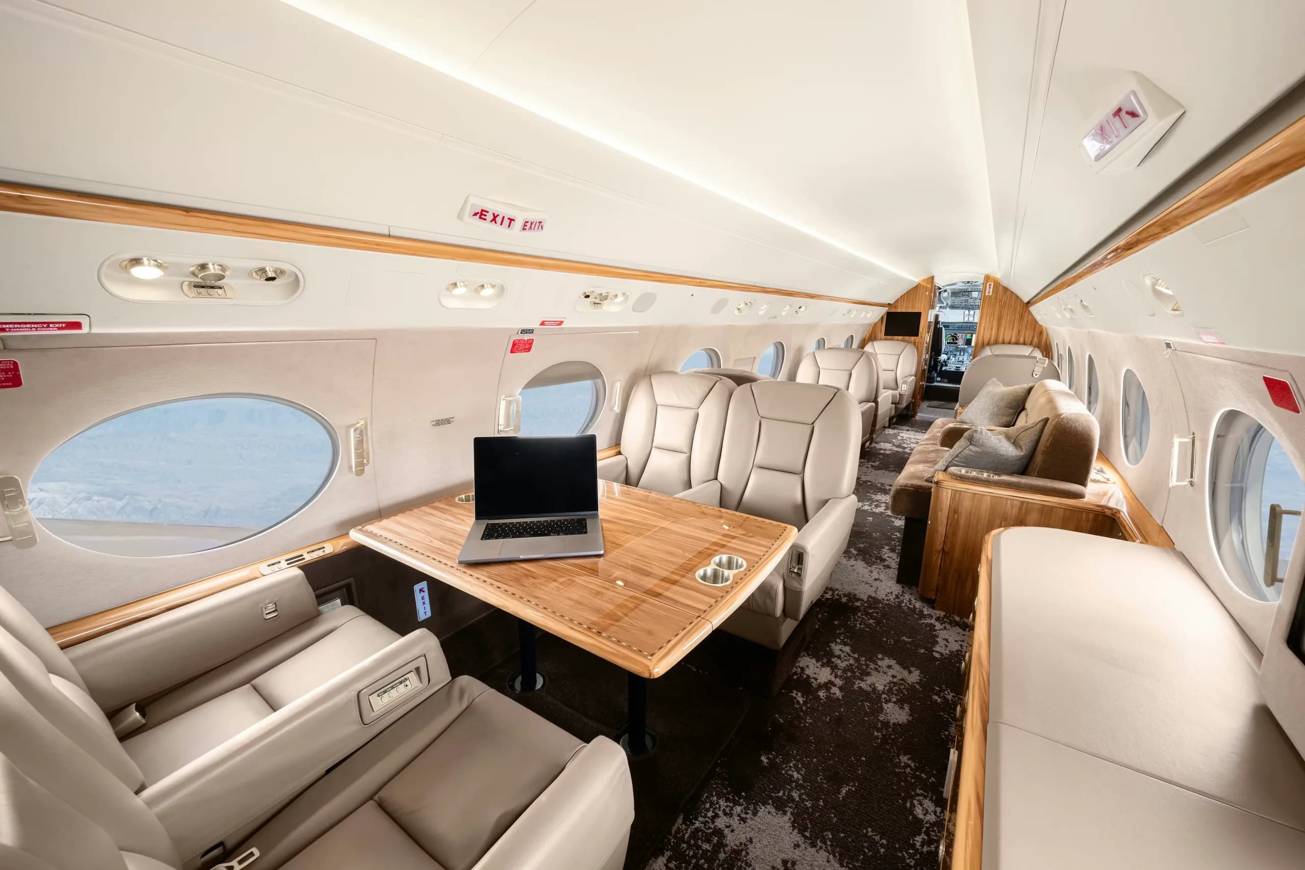 Interior view of the aircraft cabin with a laptop on the table.