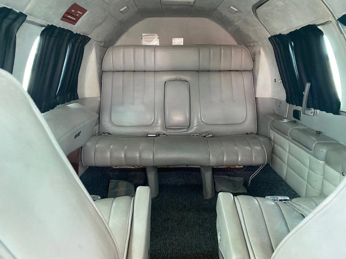 The interior of the aircraft features gray seats and black curtains.