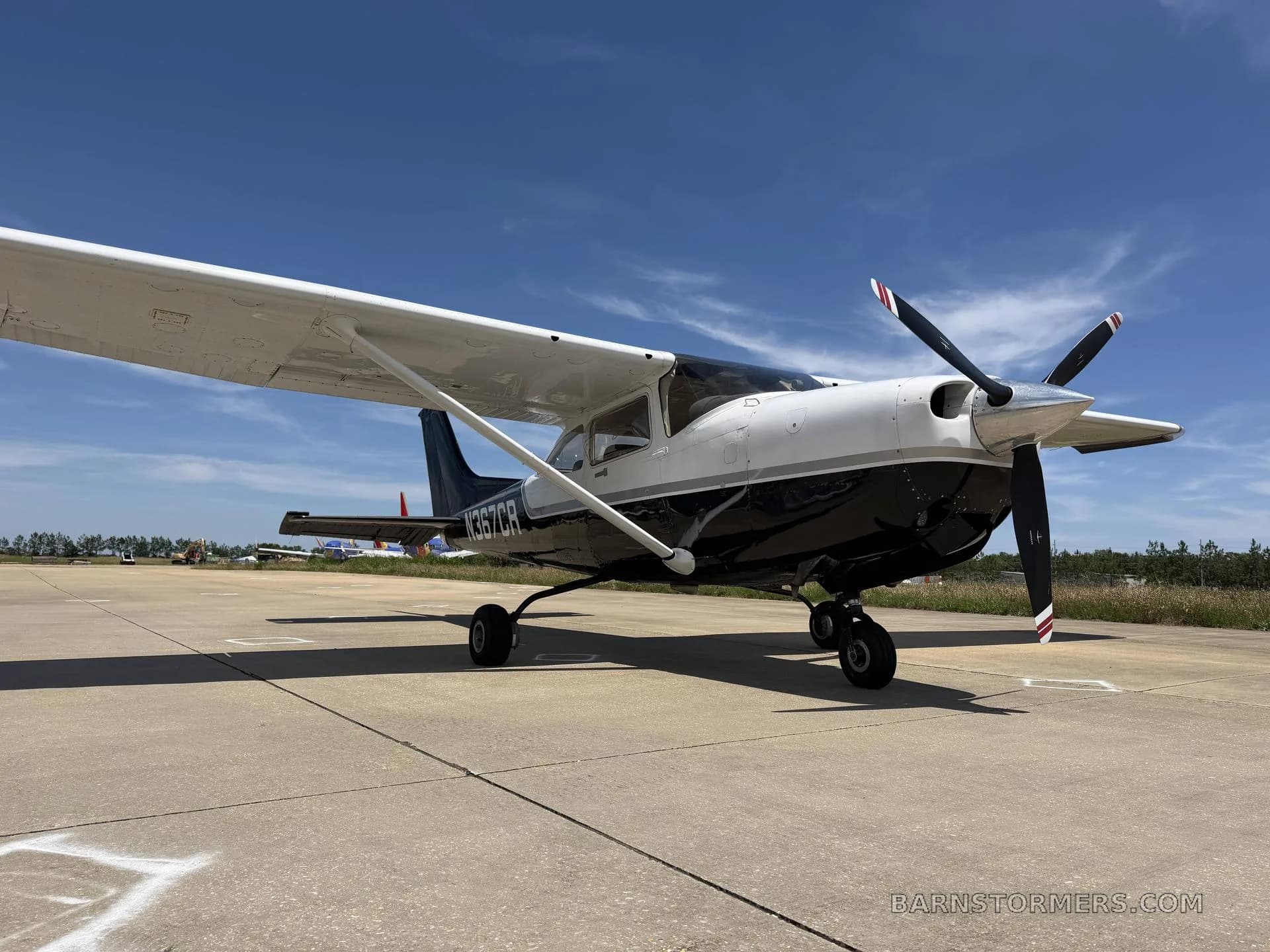 A black and white Cessna 182 Skylane (N367CR) parked on an asphalt ramp, viewed from the front-right.