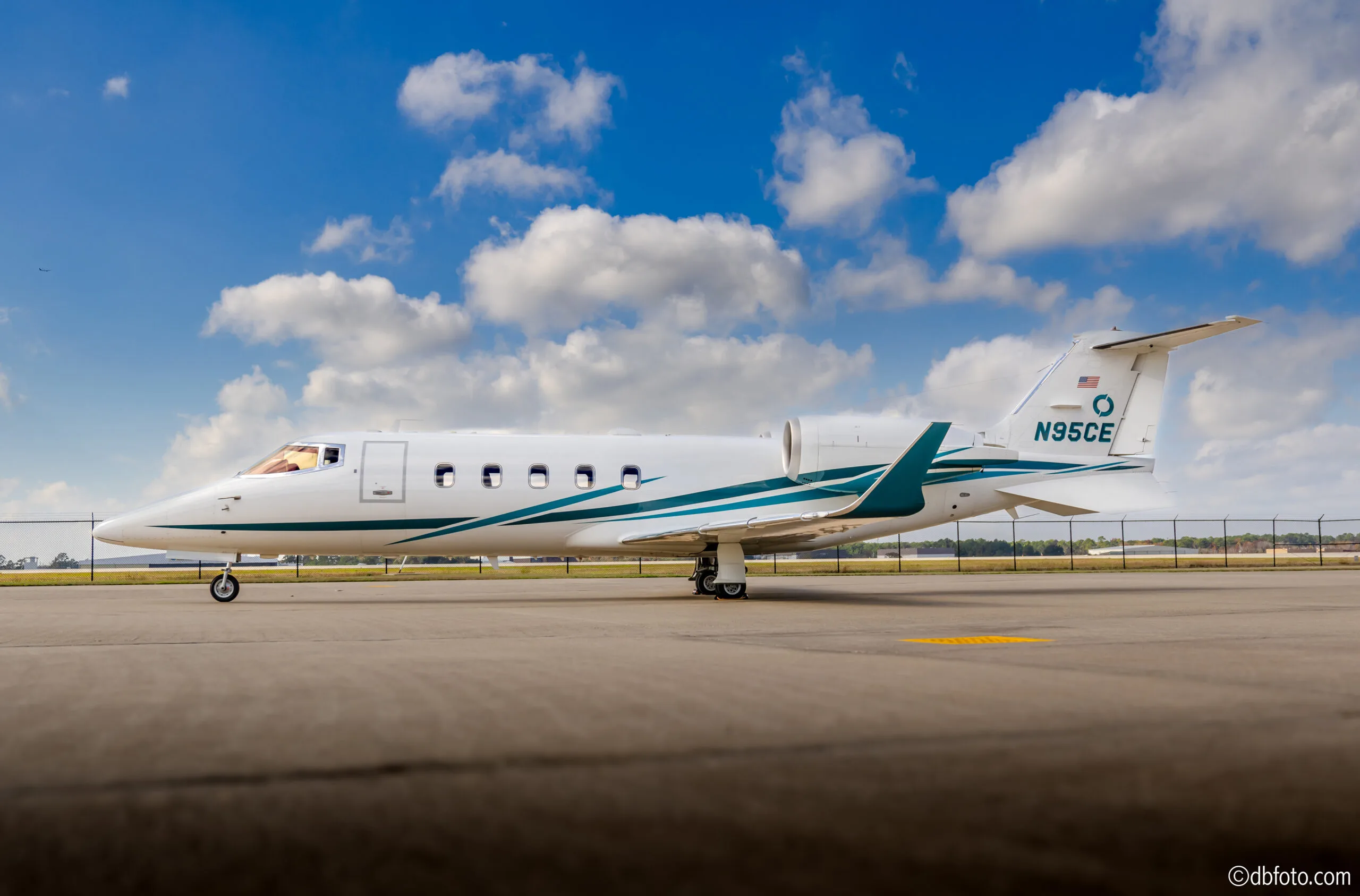 Side view of a Learjet 45 aircraft with registration N95CE on the tarmac.