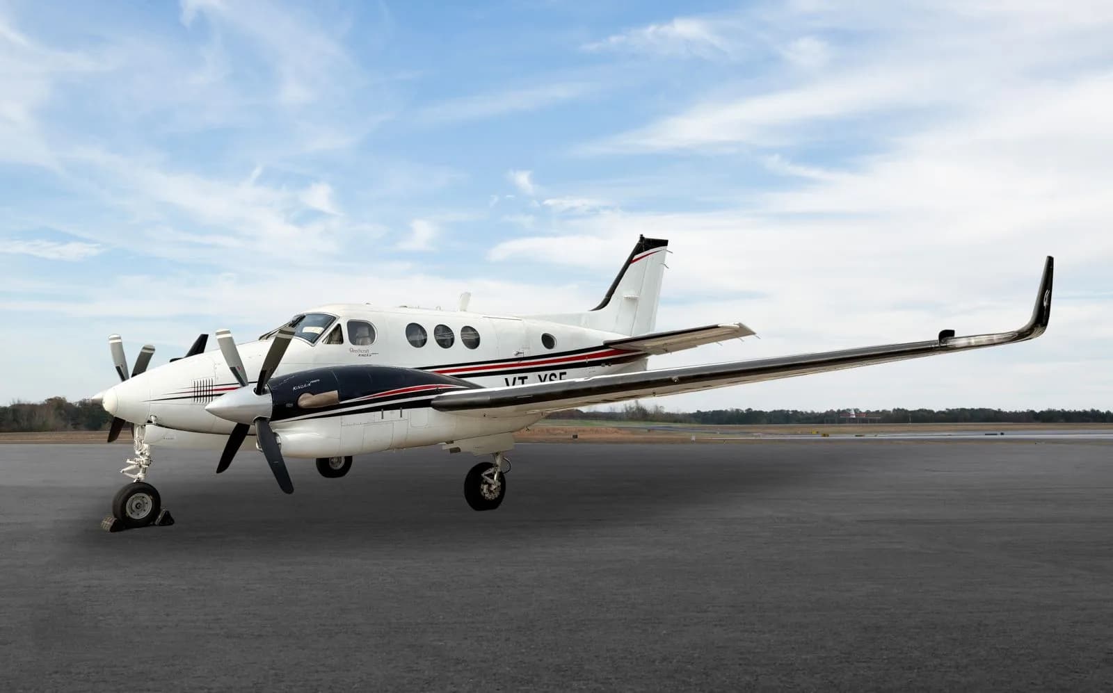 A King Air turboprop aircraft on the tarmac with a white and black paint scheme.