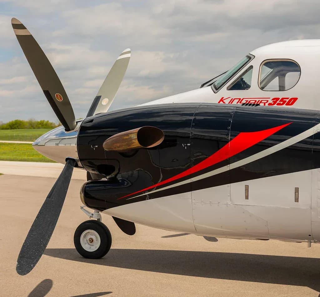 A close-up view of the front section of a Beechcraft King Air 350, showing the propeller, engine, and "KING AIR 350" text on the fuselage.