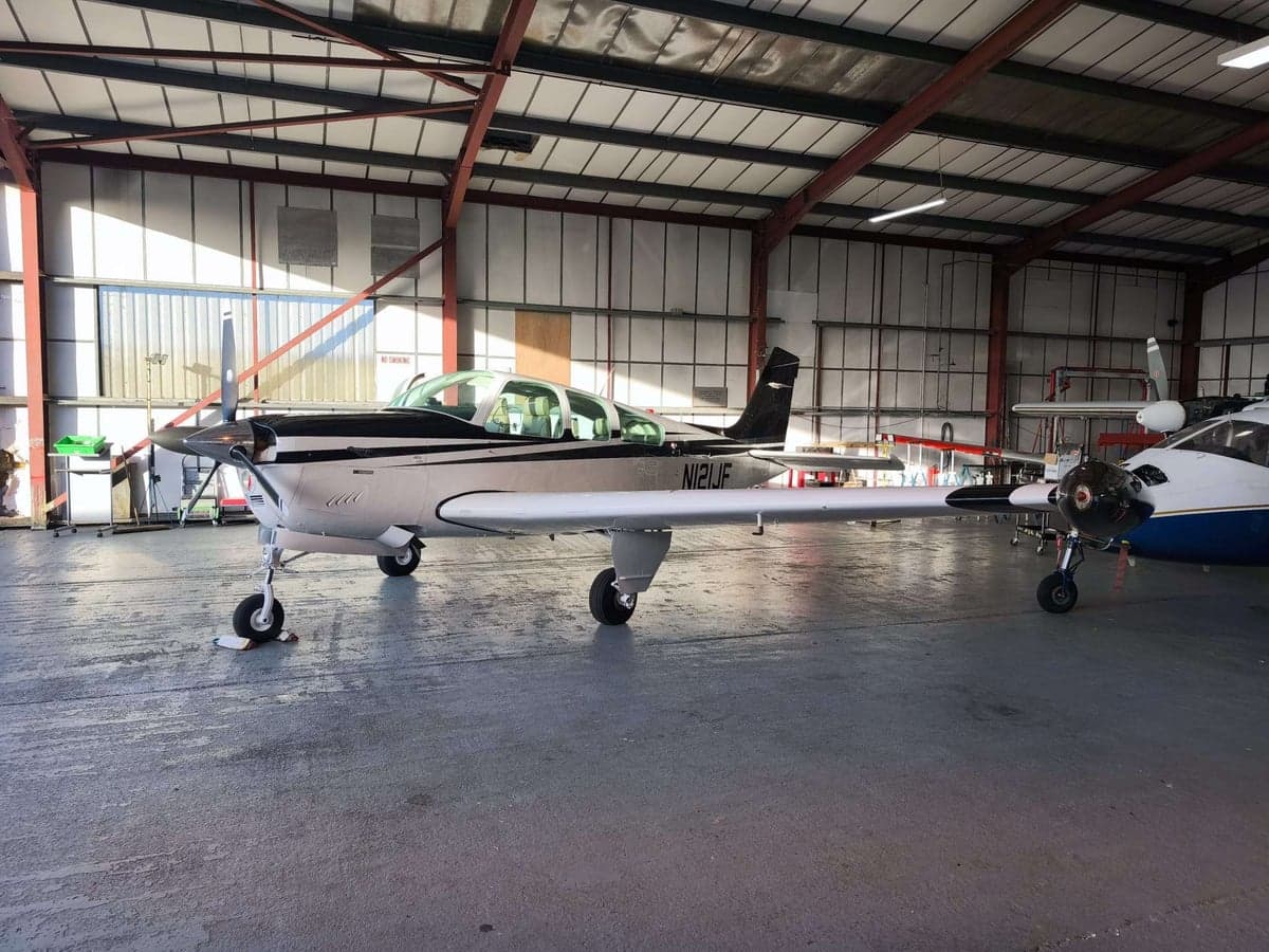 A Beechcraft Bonanza parked inside a hangar.