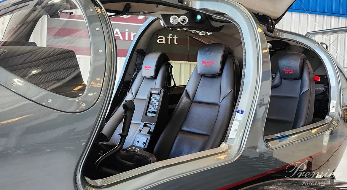 The interior of a Diamond DA62 aircraft shows the seats and side panels.