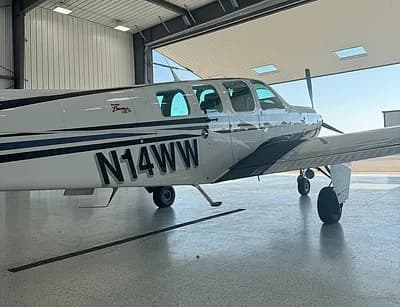 Beechcraft Bonanza in a hangar, close up of tail number N14WW.