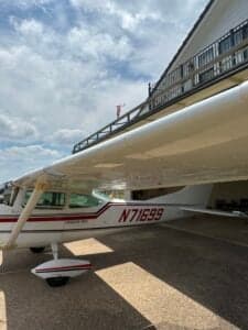 Side view of a Cessna 182 Skylane, registration N71699, parked under a covered area.