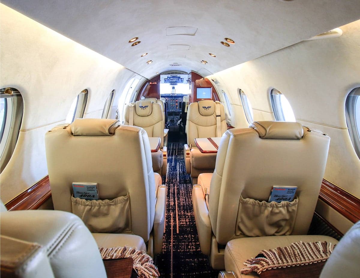 View of the Beechjet 400A cabin with tan leather seats and wood trim.