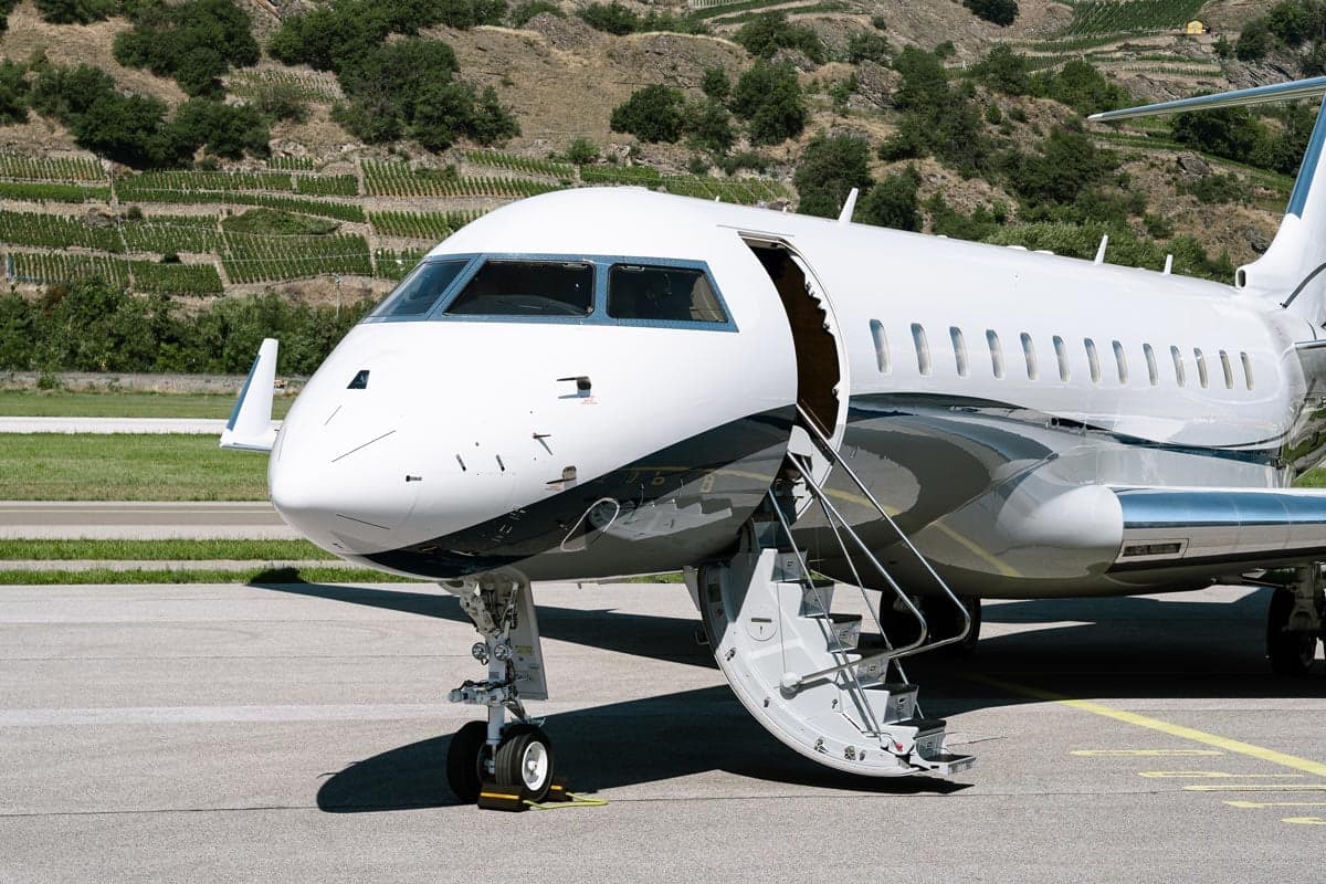 A close-up of the front of a Bombardier Global XRS aircraft with the airstair deployed.