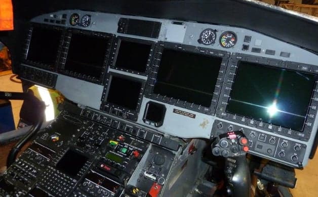 A blue and white Airbus Helicopters AS332 Super Puma on the tarmac.