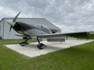 Side view of the N194PT aircraft in front of a hangar.