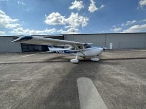 Cessna 172 Skyhawk, registration N759CB, parked on the tarmac in front of a hangar.
