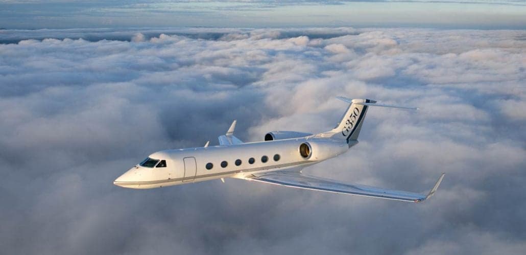 A Gulfstream G350 flying above a sea of clouds.
