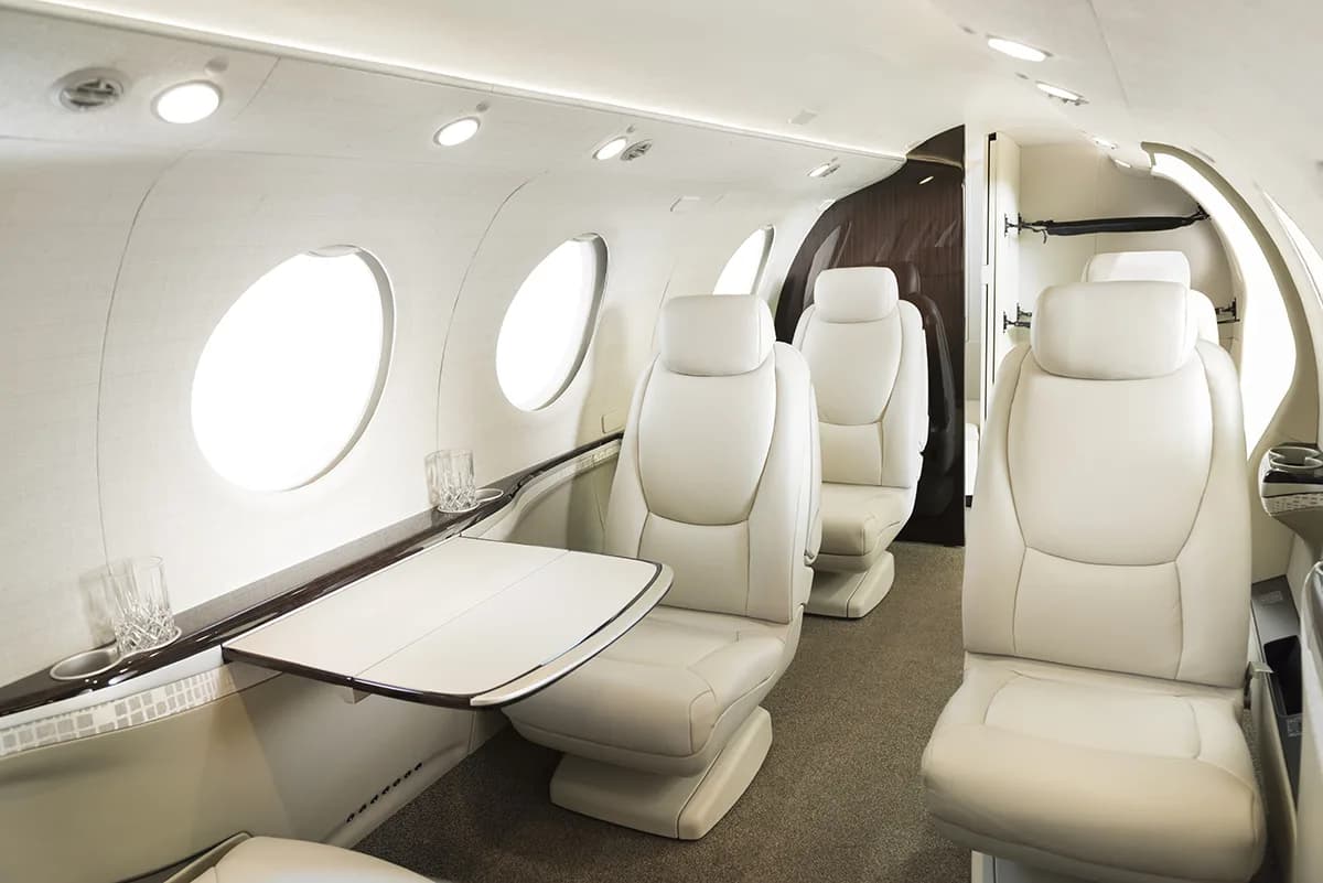 View of the aircraft interior with leather seats and a table.