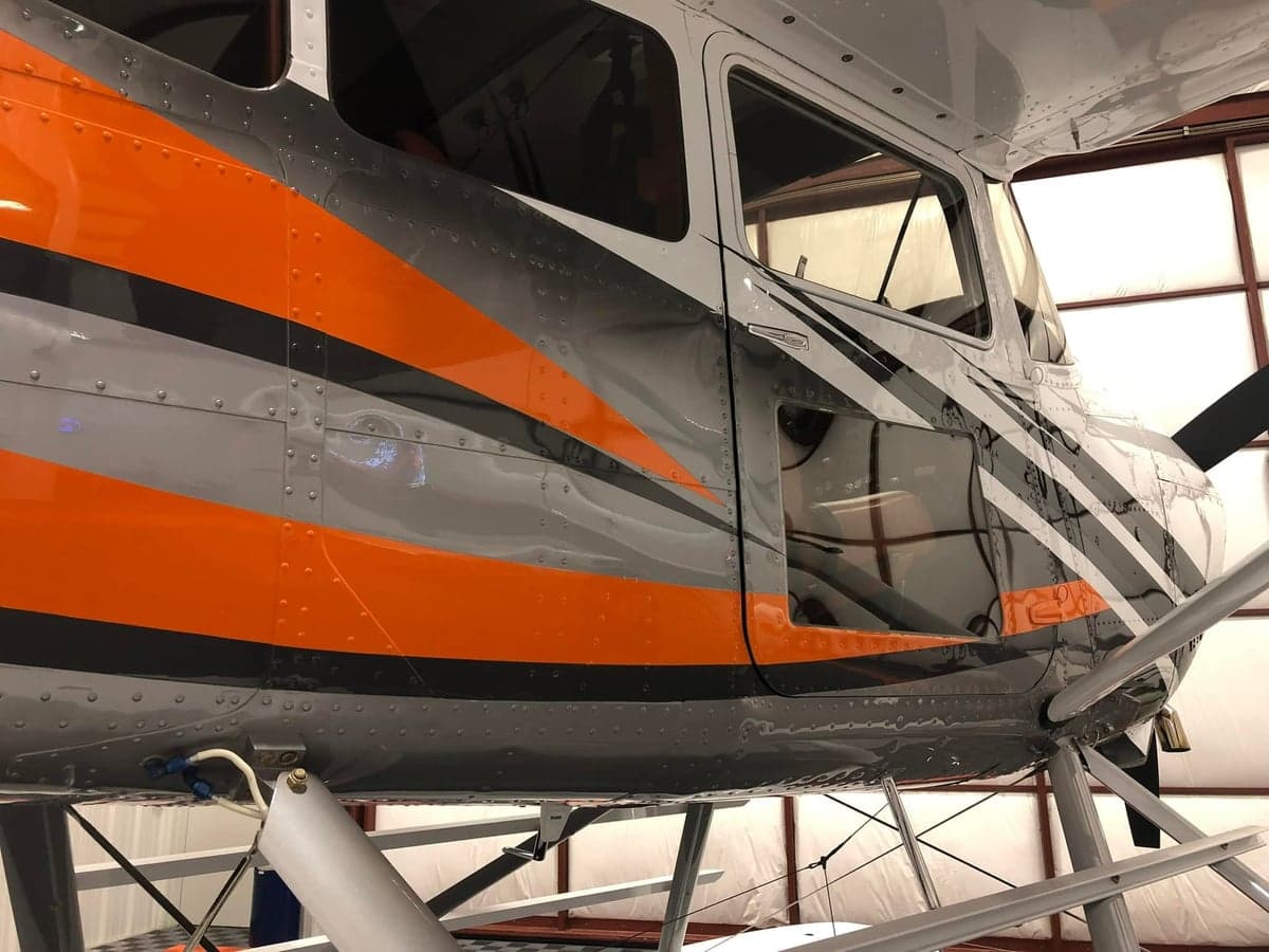 Close-up of the aircraft's exterior showing the gray, orange, and black paint scheme.