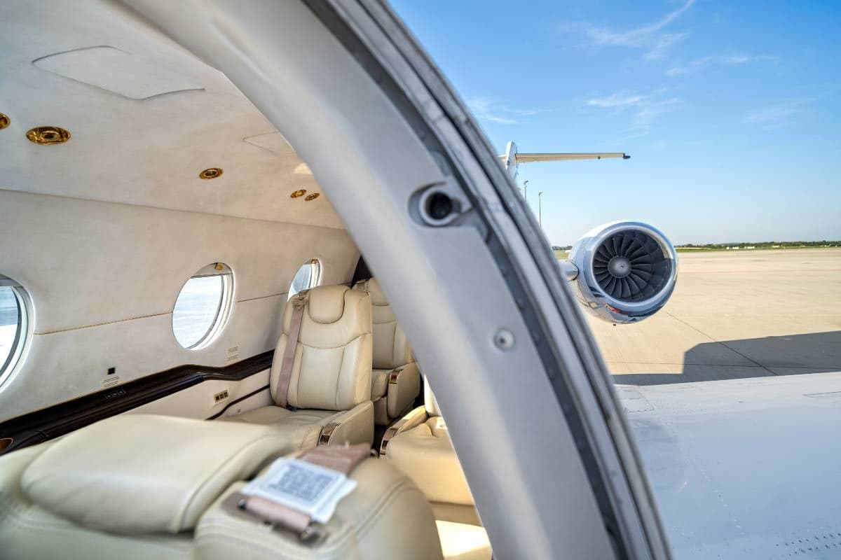 Interior view of the Beechcraft Beechjet 400A cabin with cream leather seats.