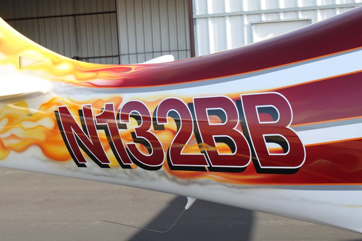 Close-up of the tail of the aircraft with the registration number N132BB and a flame design.