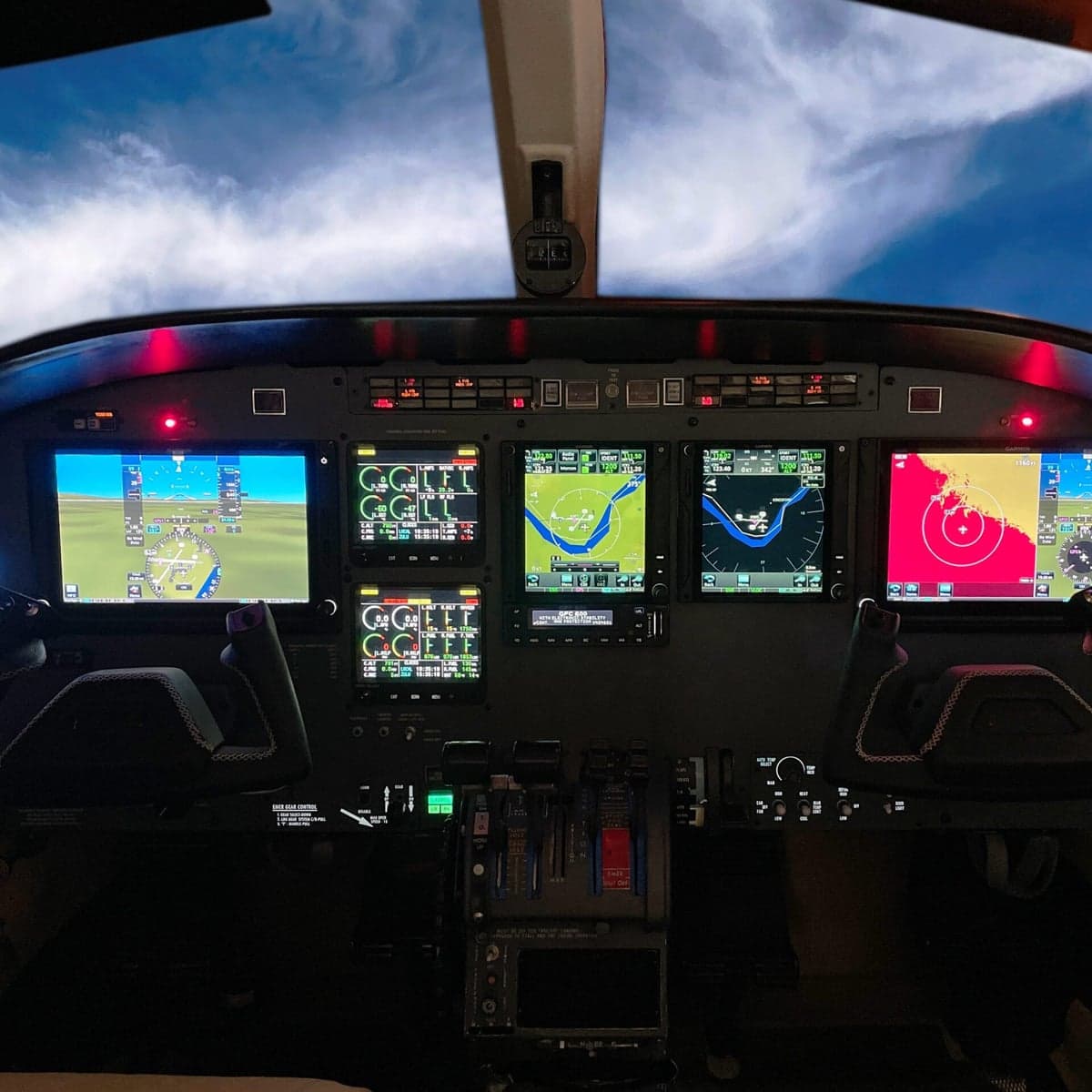 Close-up of an aircraft cockpit instrument panel with multiple displays.
