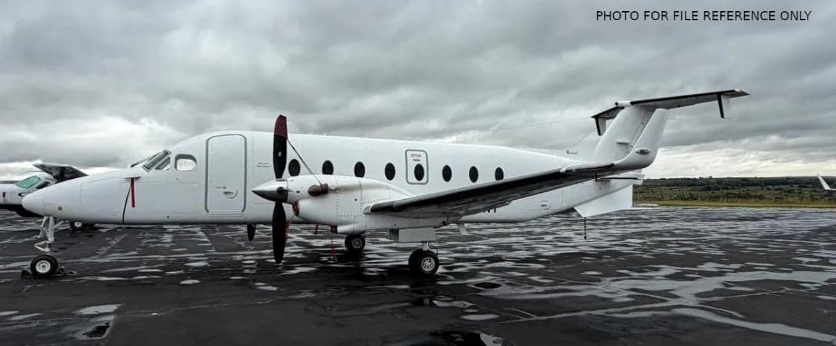 Side view of a white Beechcraft 1900 on the tarmac.