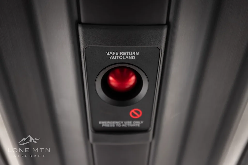 A close-up of the "SAFE RETURN AUTOLAND" button with a red indicator light on an overhead panel.